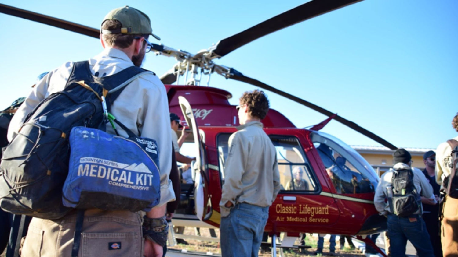 Men standing in front of helicopter with medical kit