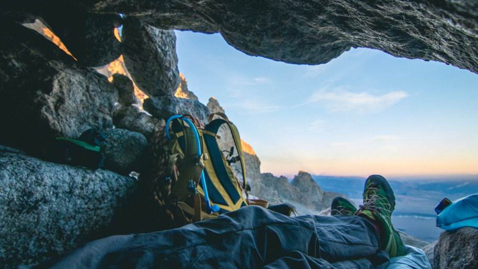 May laying in cave with backpack