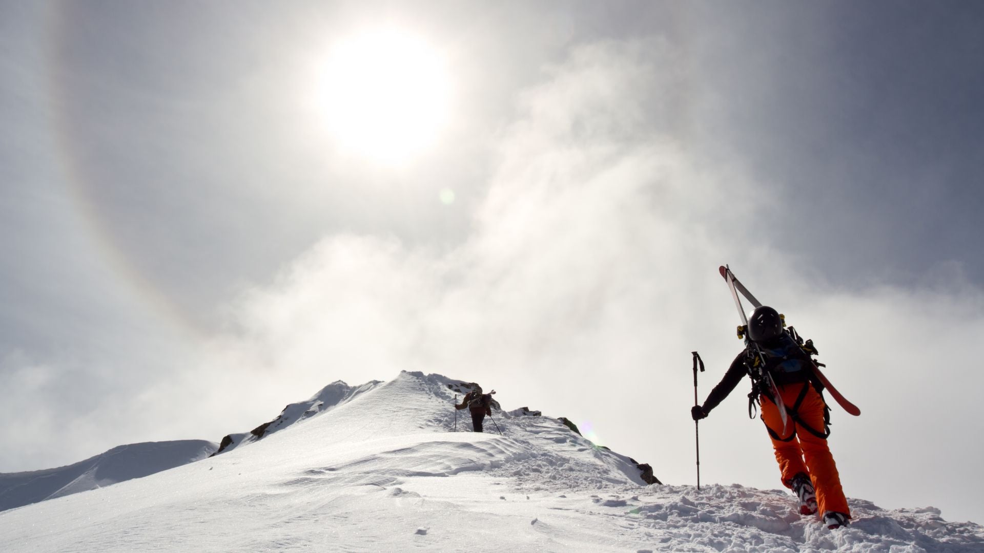 Man hiking with ski gear in winter