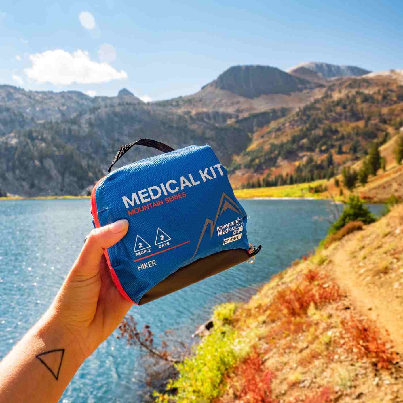 Mountain Series Medical Kit - Hiker holding kit in front of lake