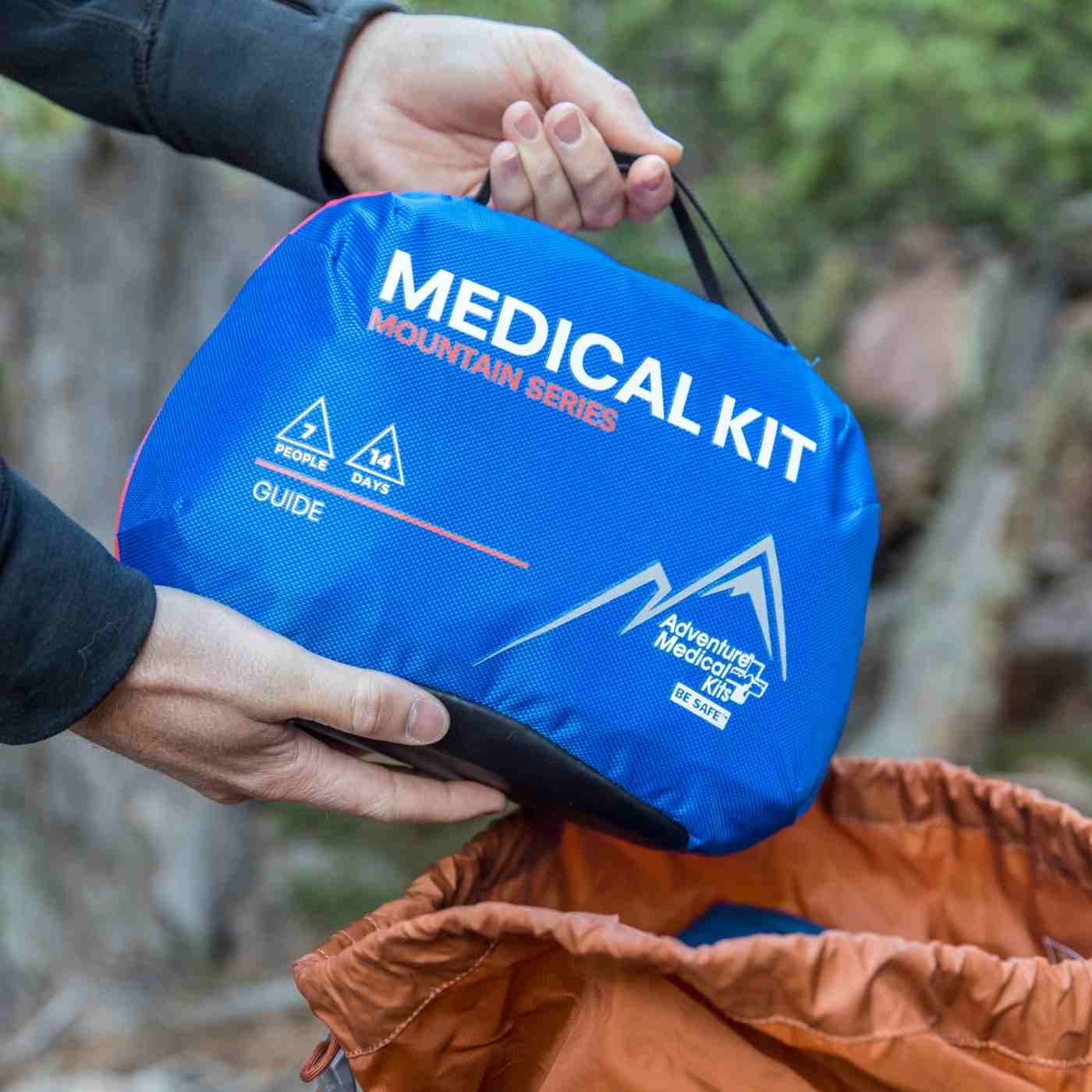 Mountain Series Medical Kit - Guide pulling from orange backpack