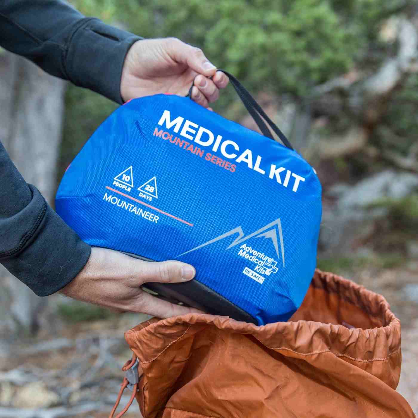Mountain Series Medical Kit - Mountaineer pulling kit from orange backpack