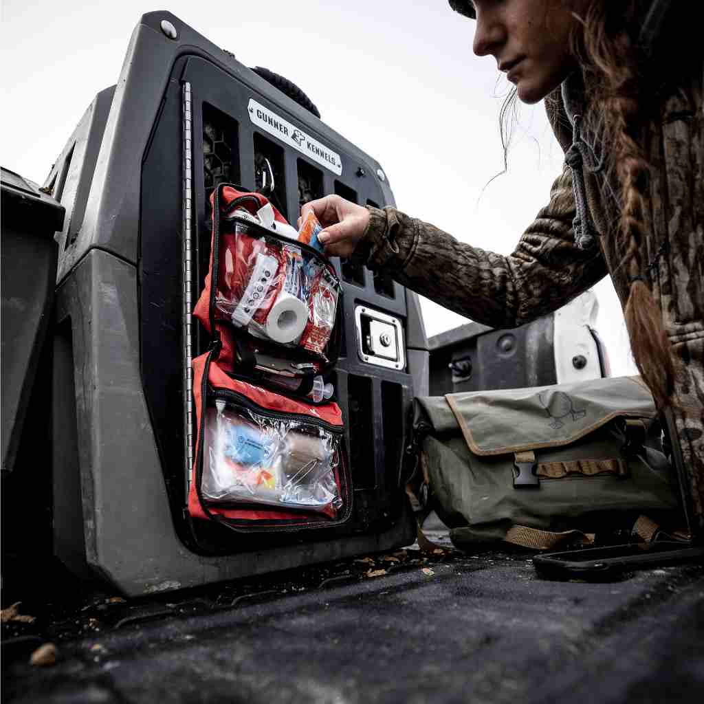 Sportsman Series Medical Kit - 300 hunter removing contents from kit on dog kennel on truck