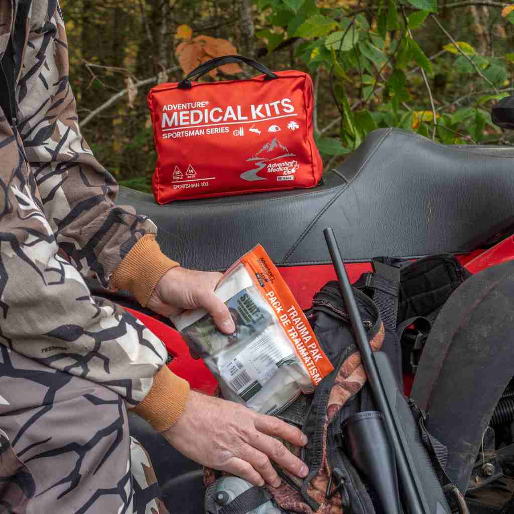 Sportsman Series Medical Kit - 400 hunter putting removable trauma pak into backpack with larger kit on ATV seat
