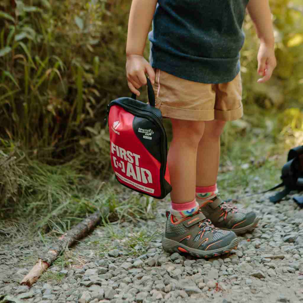 Adventure First Aid, 1.0 child holding kit while hiking