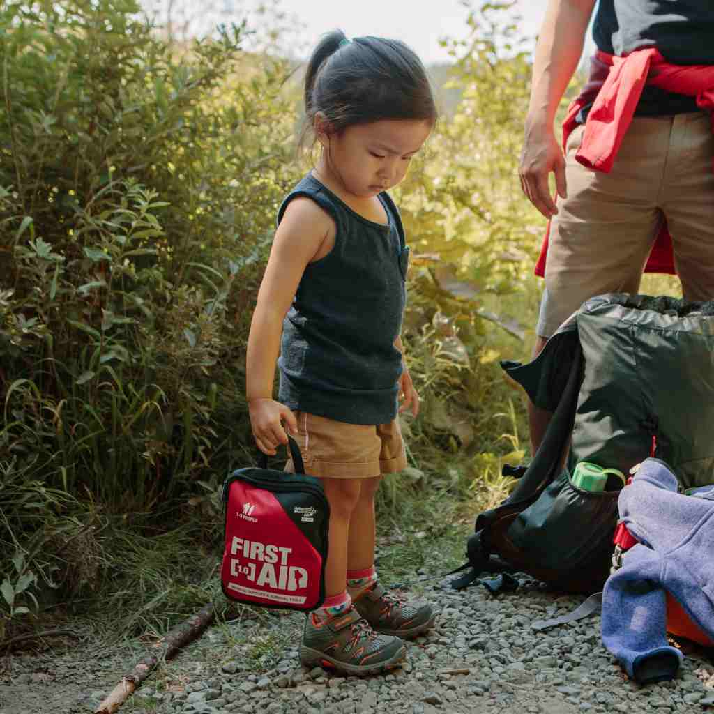 Adventure First Aid, 1.0 child holding kit while on hike