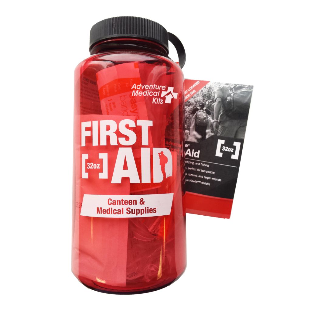 A red plastic canteen bottle with a black cap and carry loop, labeled 'FIRST AID 32oz' by Adventure Medical Kits, shown with a matching first aid packet on a white background.