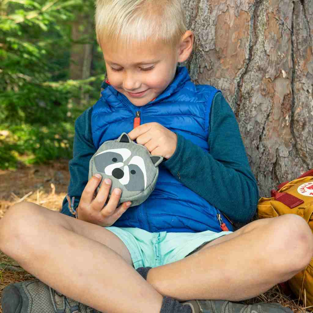 Backyard Adventure Raccoon First Aid Kit child opening kit seated in front of tree