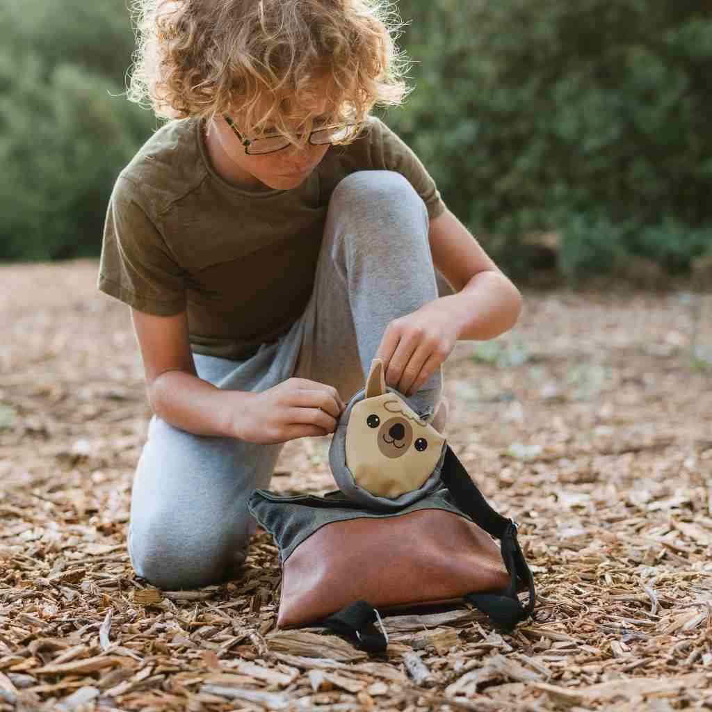 Backyard Adventure Llama First Aid Kit child opening kit while seated on the ground