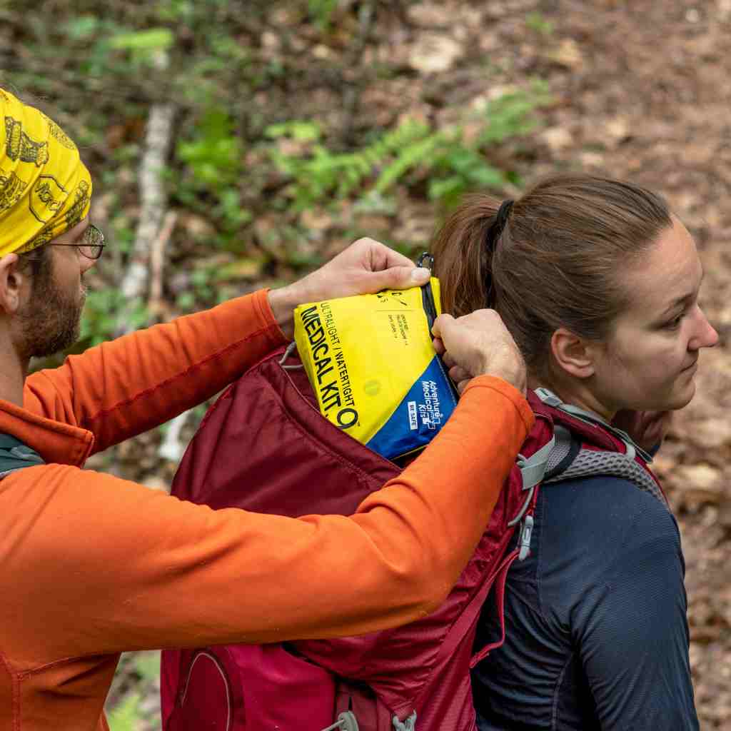 Ultralight/Watertight Medical Kit - .9 friend removing kit from hiker's backpack