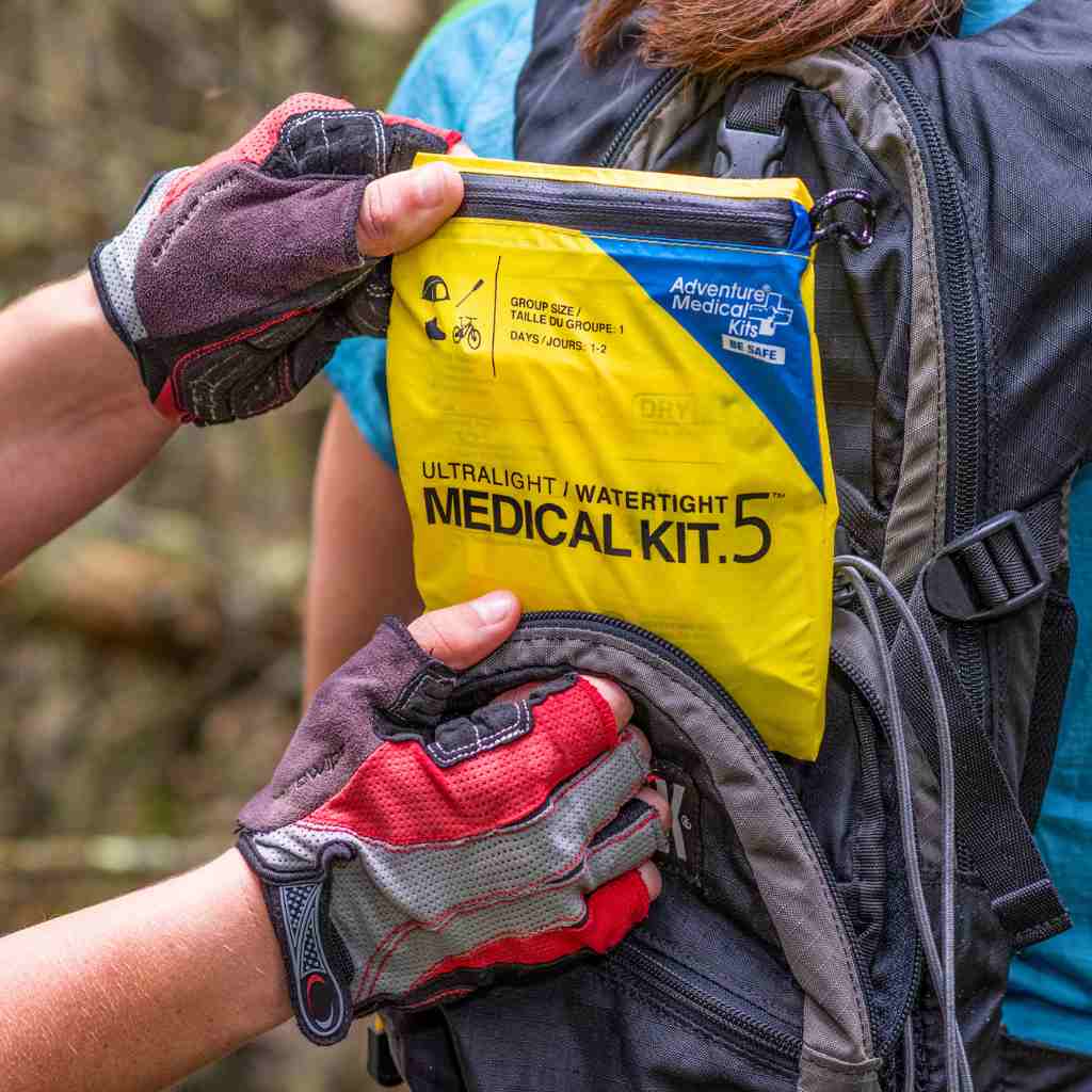 Ultralight/Watertight Medical Kit - .5 removing kit from biker's backpack