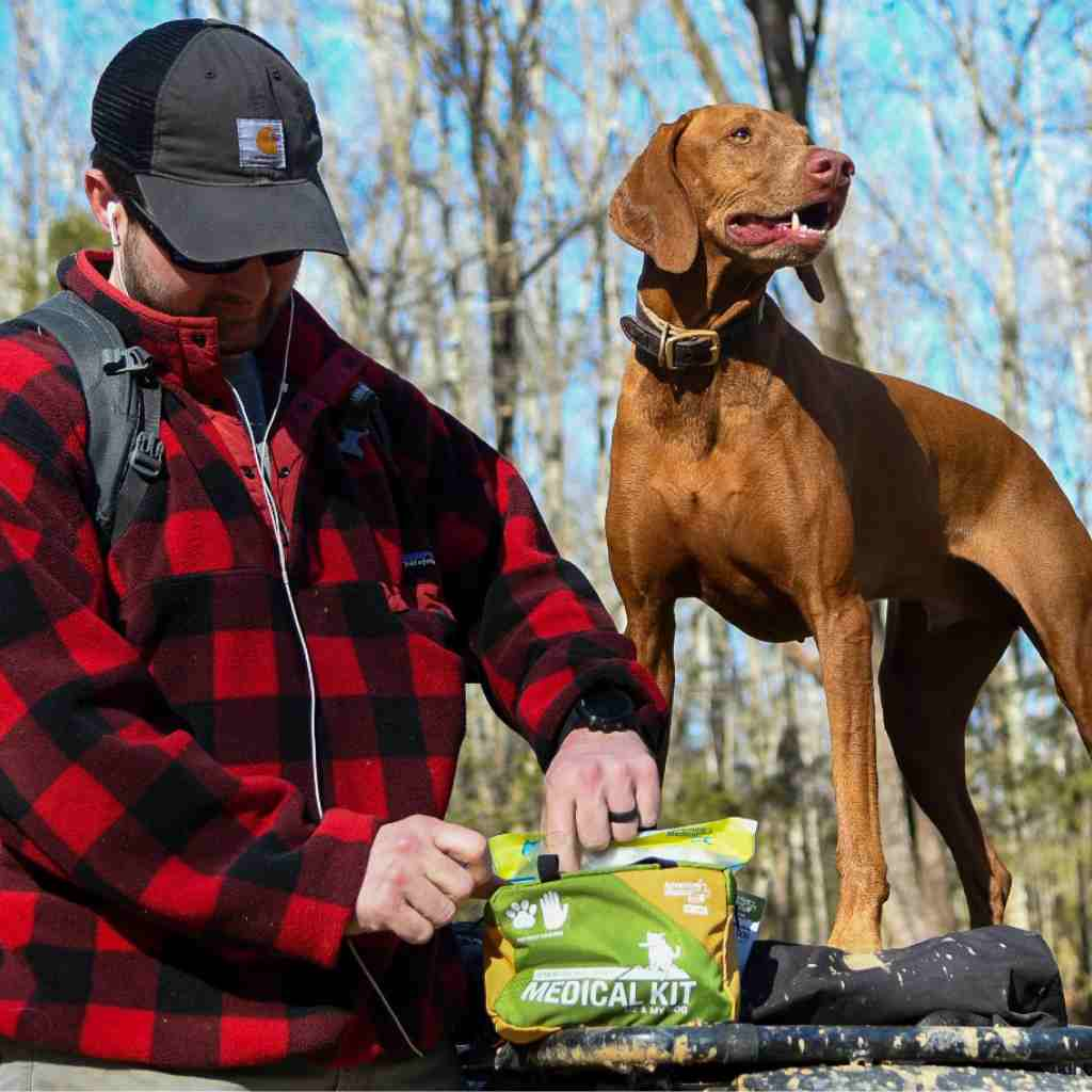 Adventure Dog Medical Kit - Me & My Dog man in red plaid jacket next to brown dog opening kit