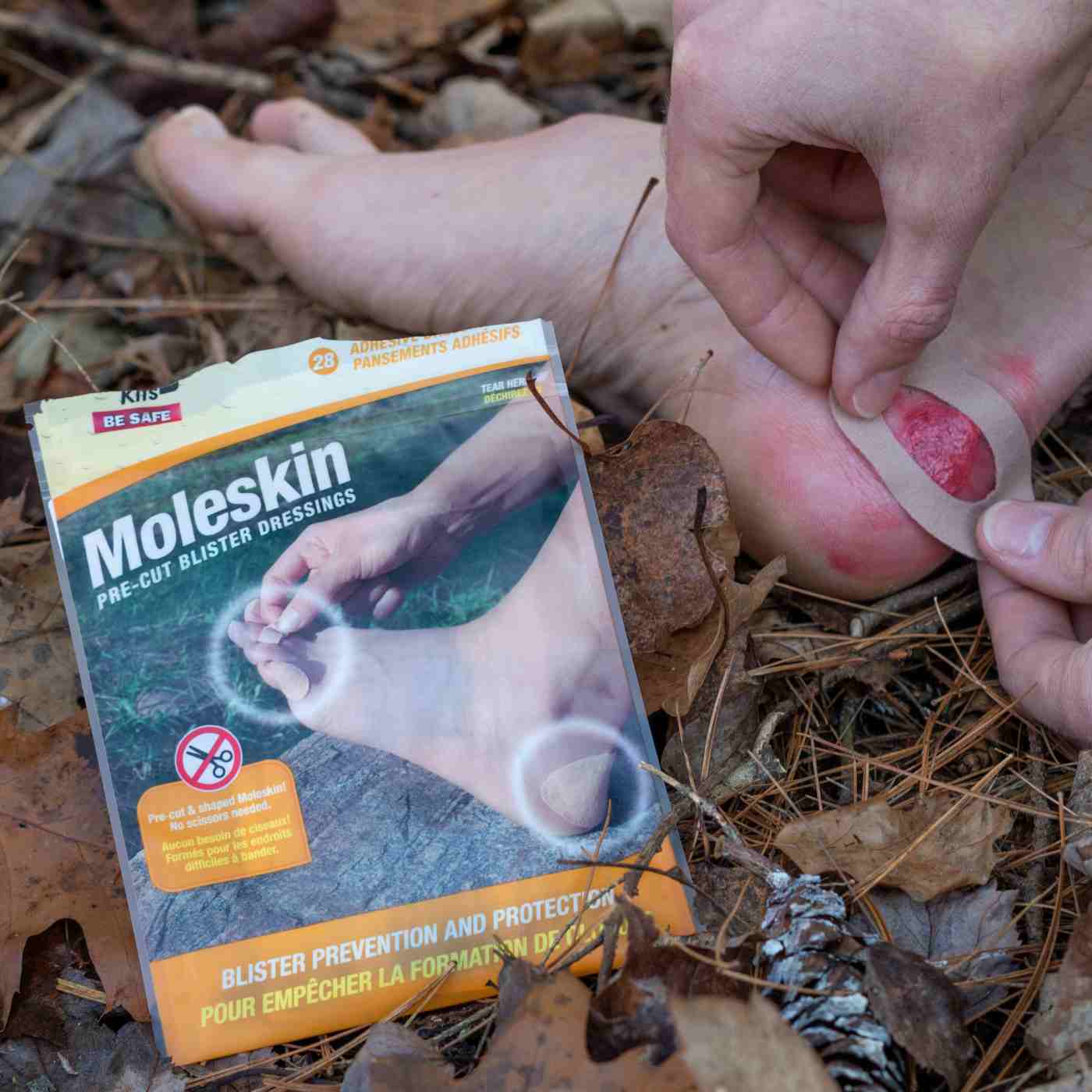 Moleskin Pre-Cut and Shaped applying to blister on foot on leaves next to package