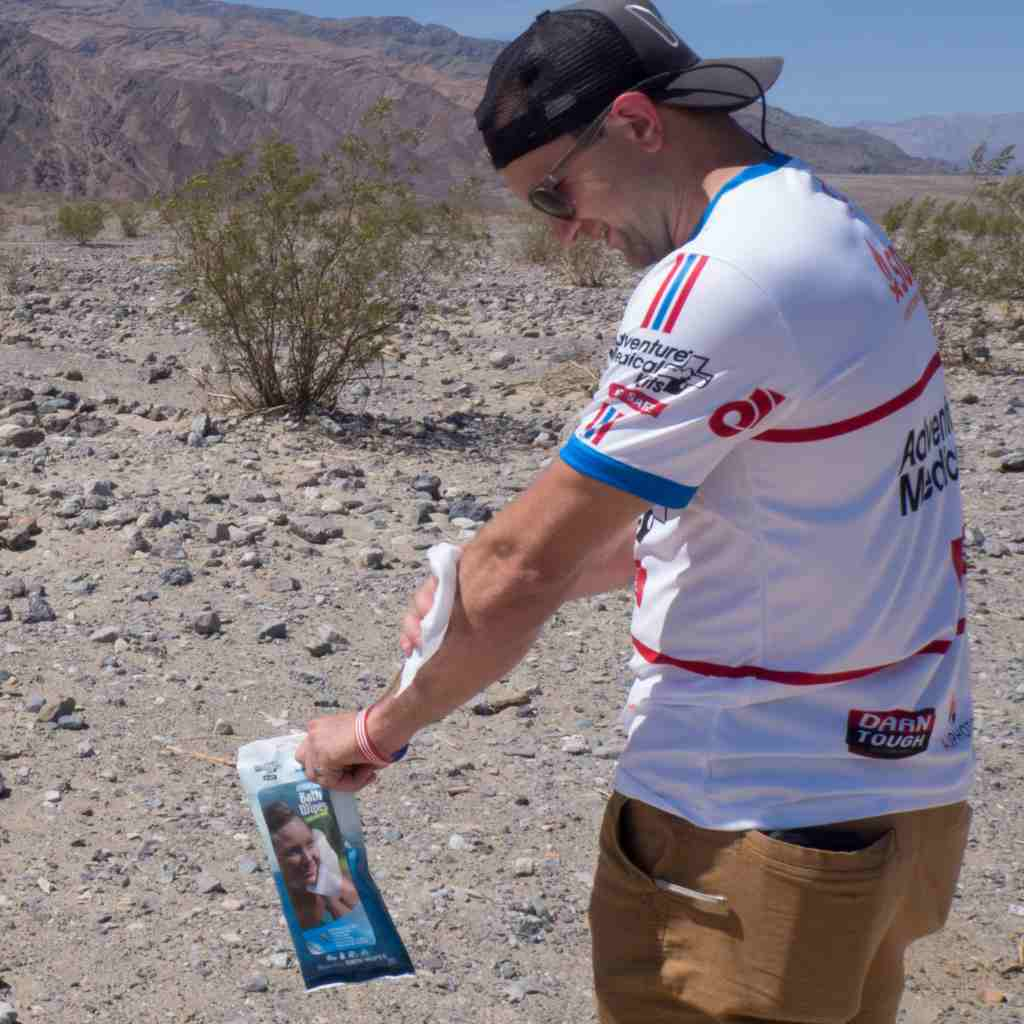 Man applying Adventure Bath Wipes in desert scene