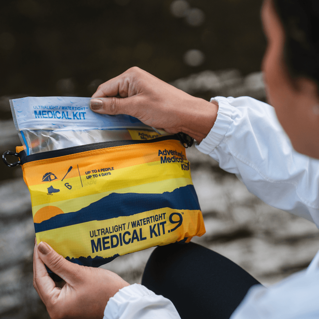 Woman opening the Ultralight / Watertight .9 kit and pulling out the waterproof inner bag