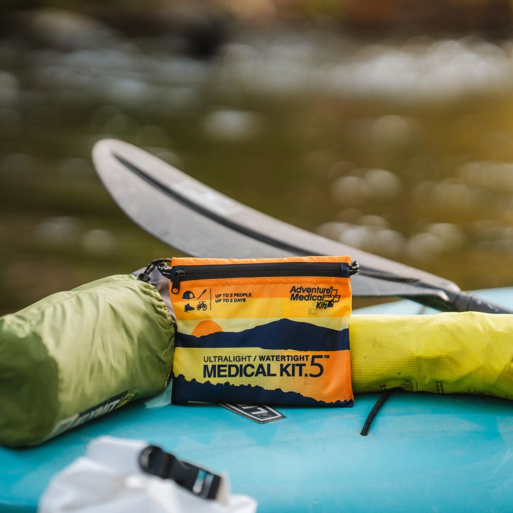 Adventure Medical Kits medical kit on a kayak with a blurred natural background