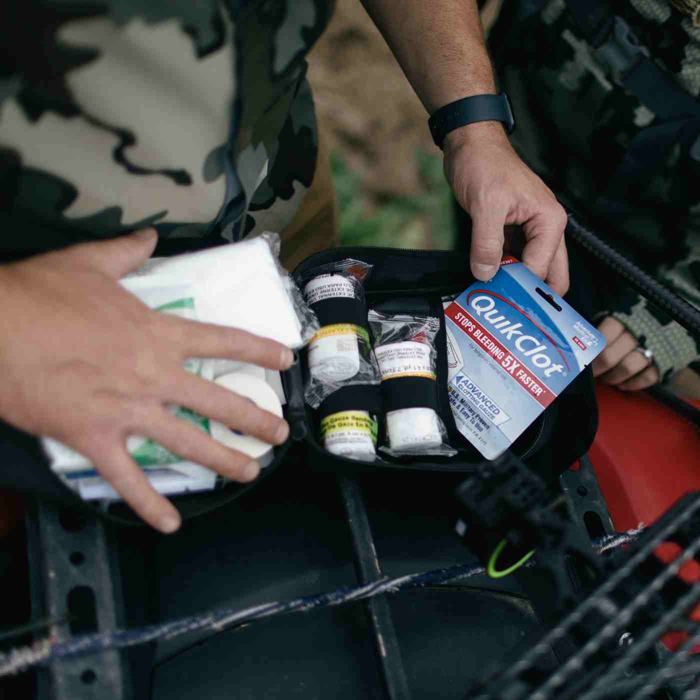 MOLLE Bag Trauma Kit 2.0 - Black opening kit and pulling out QuikClot