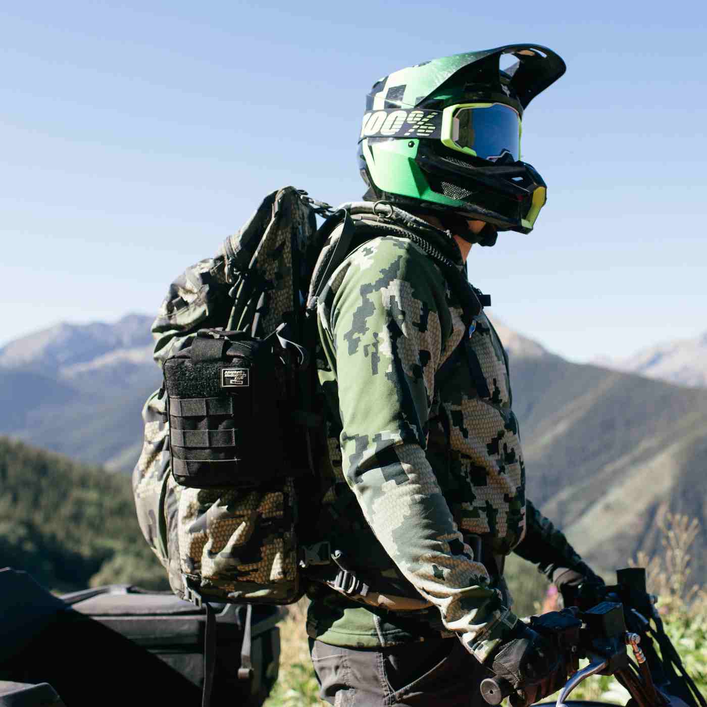 MOLLE Bag Trauma Kit 2.0 - Black person in camo and helmet wearing kit on backpack riding ATV