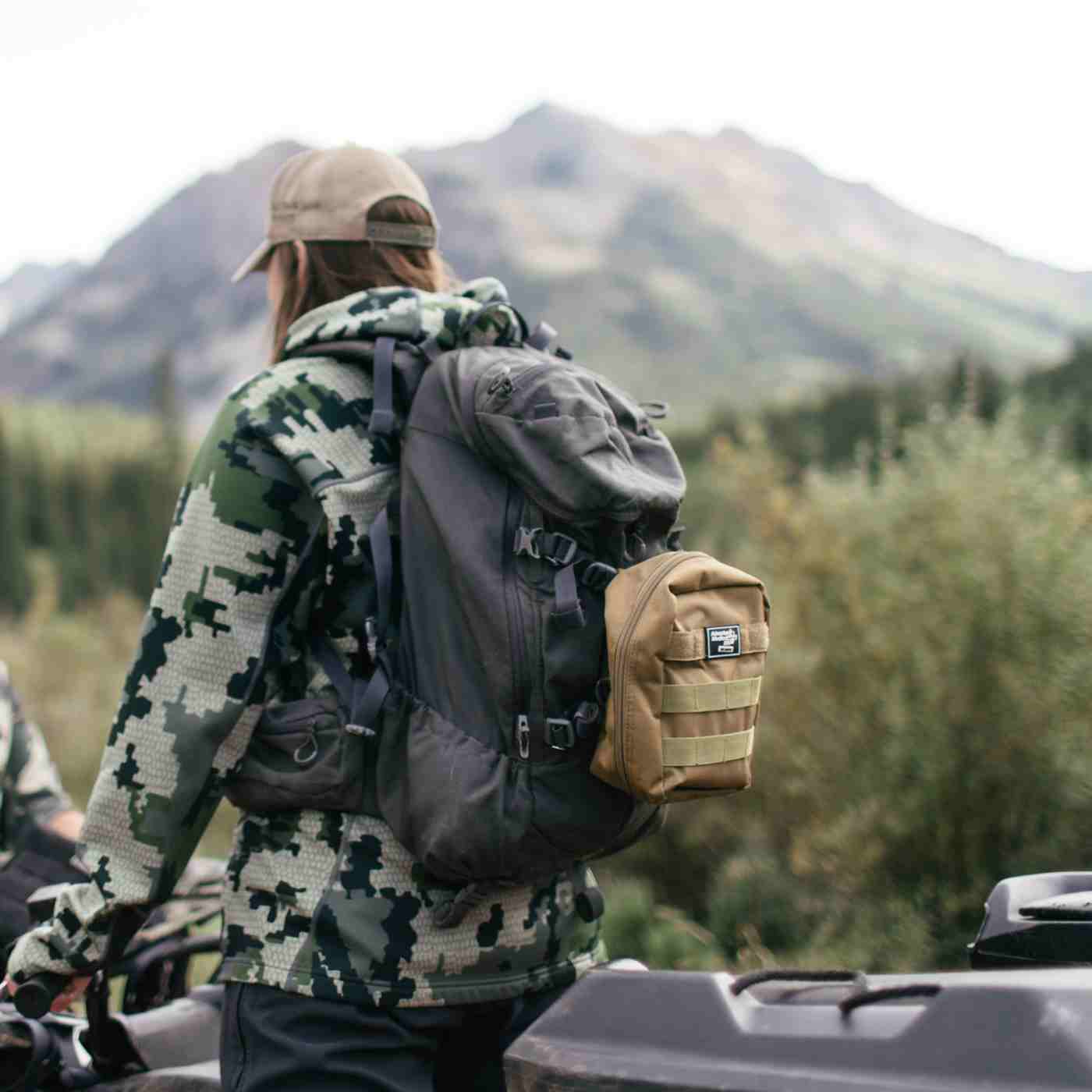 MOLLE Bag Trauma Kit 2.0 - Khaki kit on black backpack of woman in camo on ATV