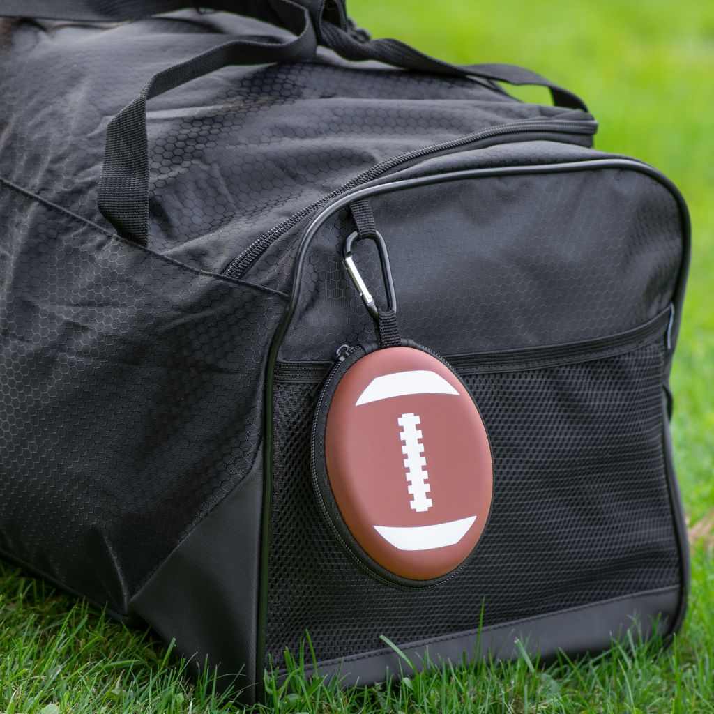 Black duffel bag with a football-shaped first aid kit on grass