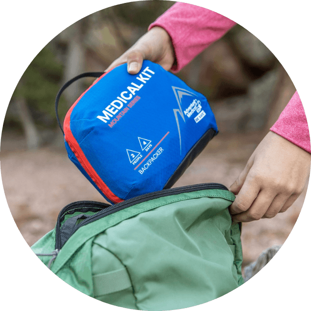 Woman storing kit in her backpack