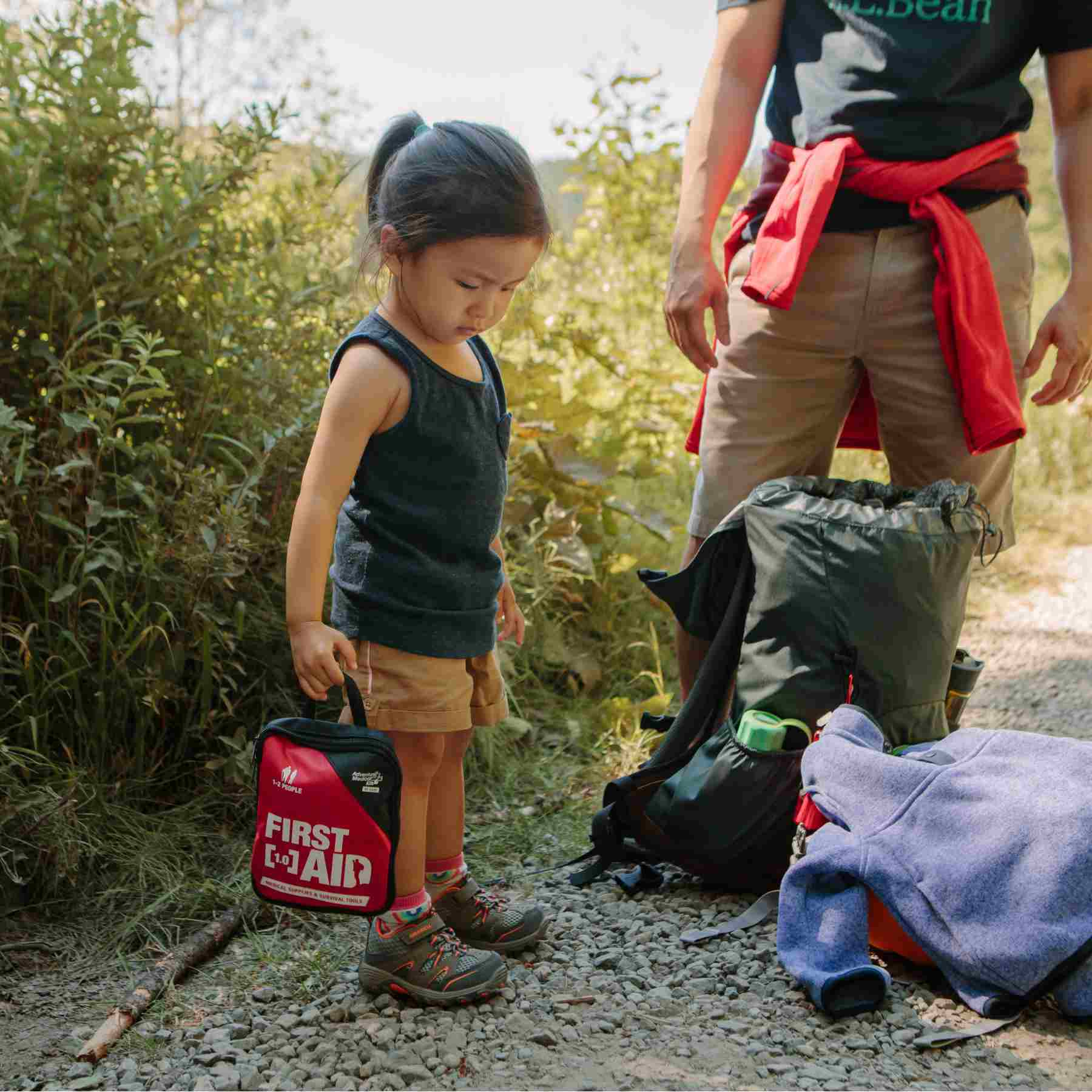 Adventure First Aid, 1.0 child holding kit while on hike