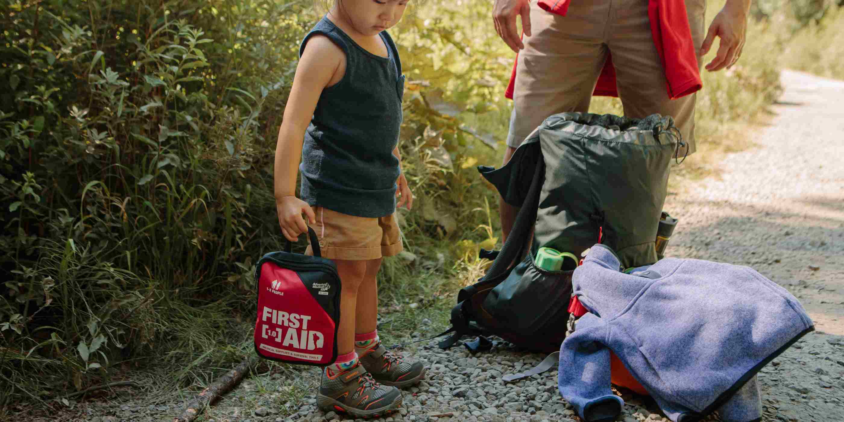 Adventure First Aid, 1.0 child holding kit while on hike