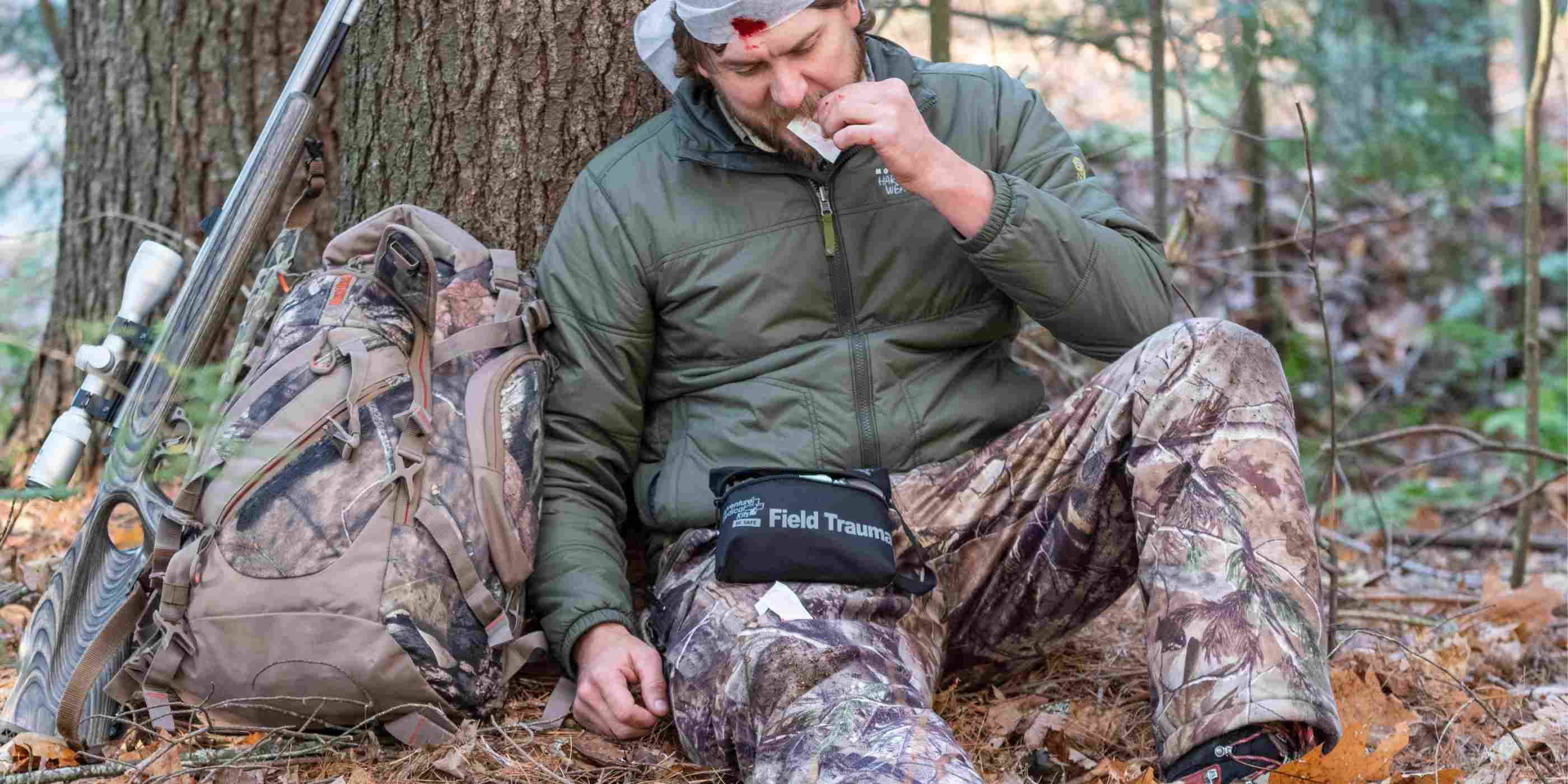 Tactical Medical Kit - Field Trauma with QuikClot hunter man using kit while seated with head injury