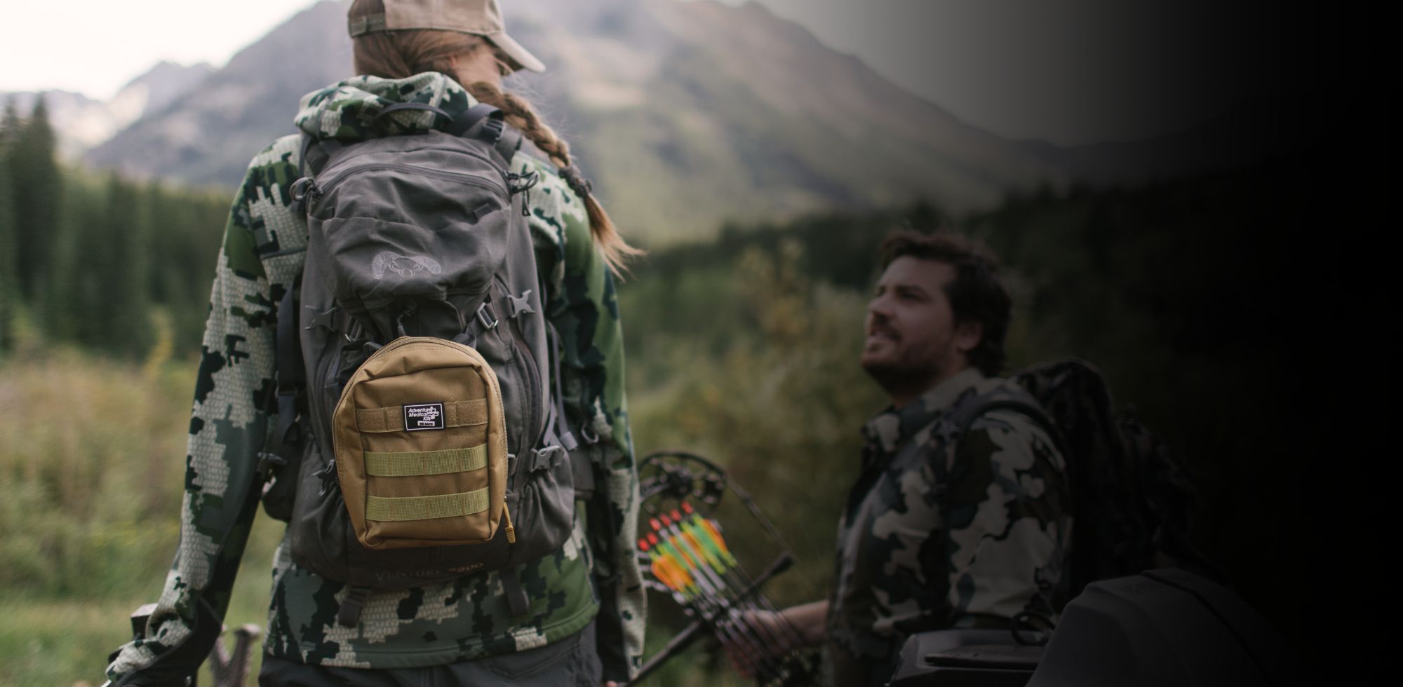 Woman in camo with MOLLE kit on backpack