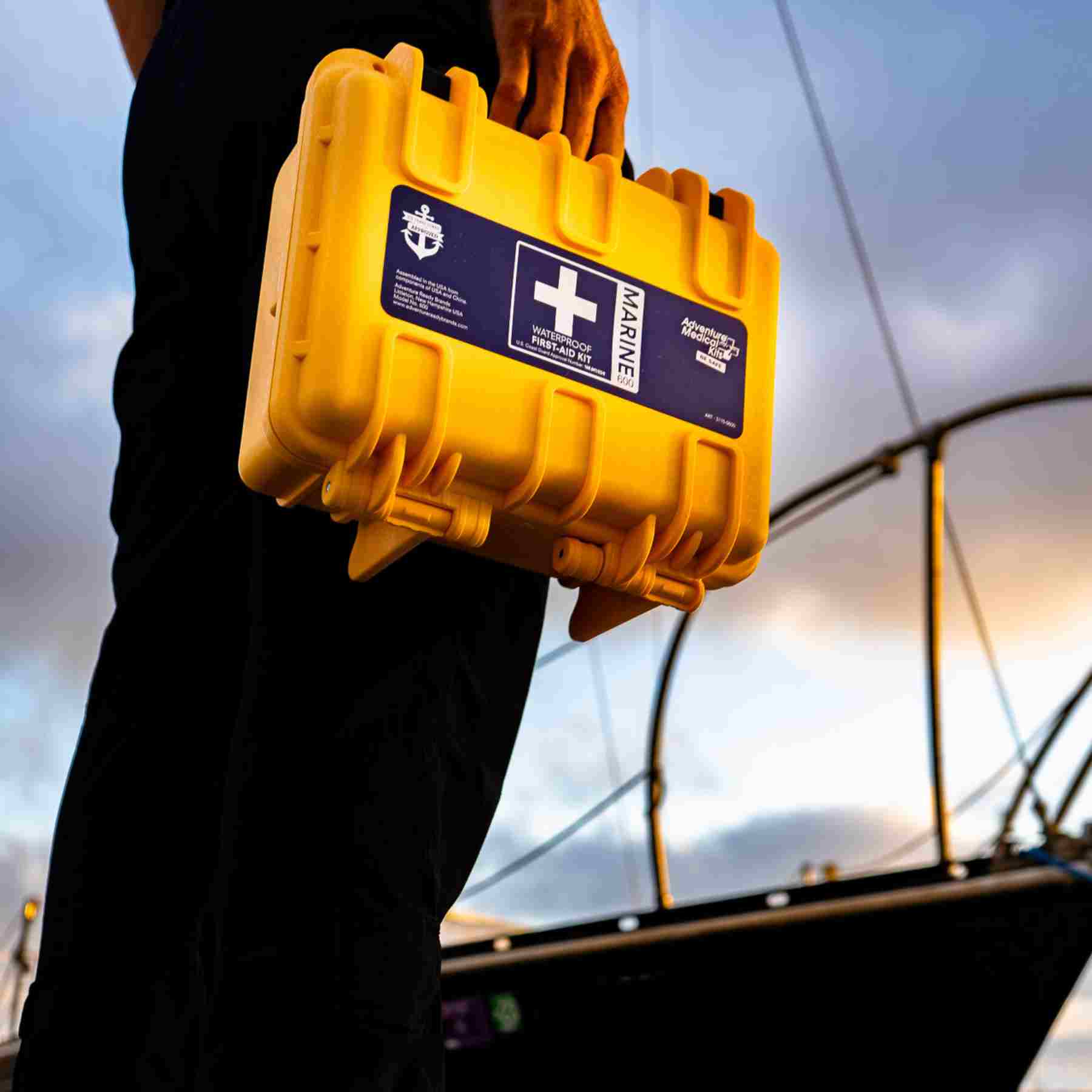 Marine Series Medical Kit - 600 man holding while in front of boat