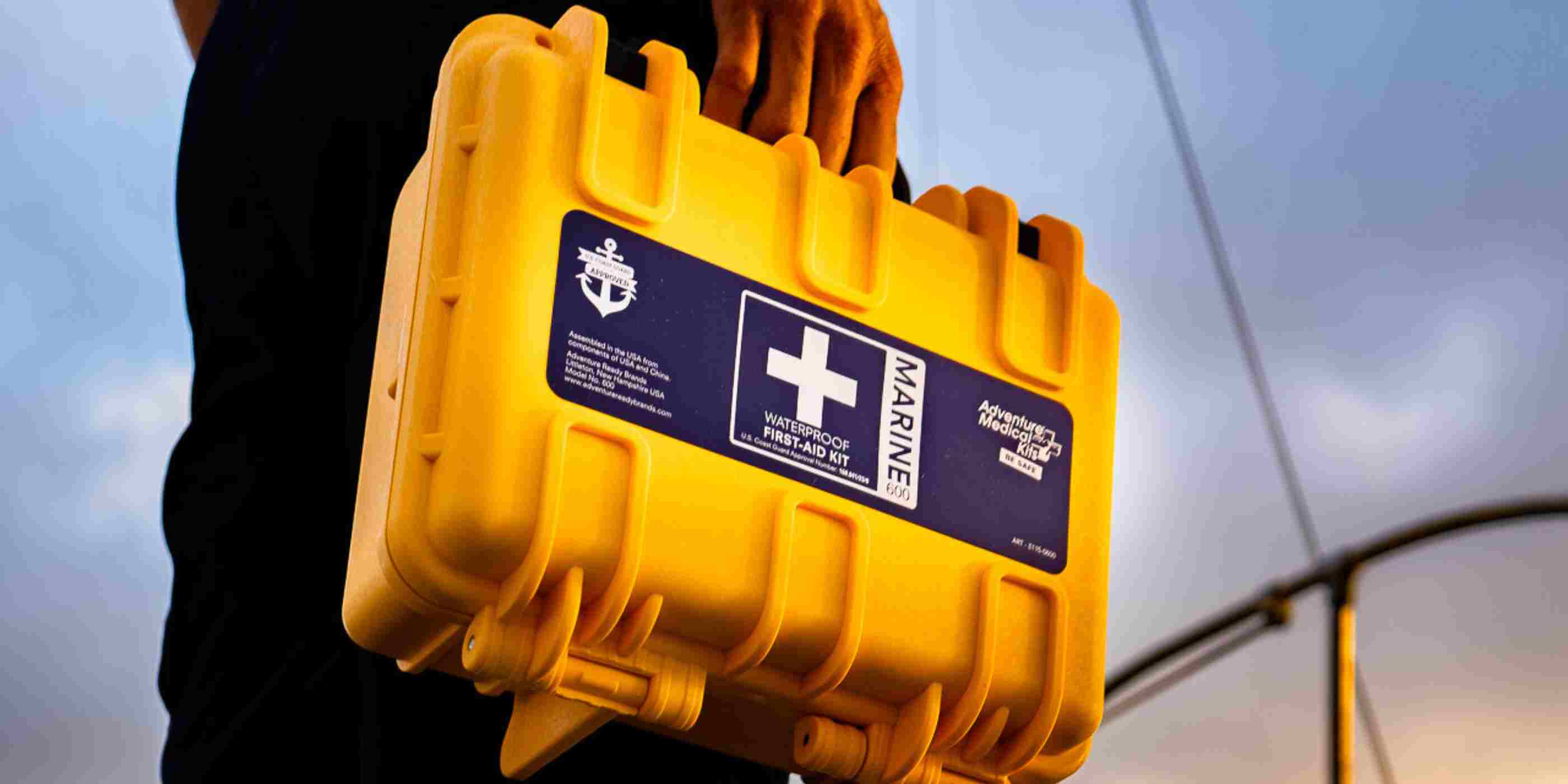 Marine Series Medical Kit - 600 man holding while in front of boat