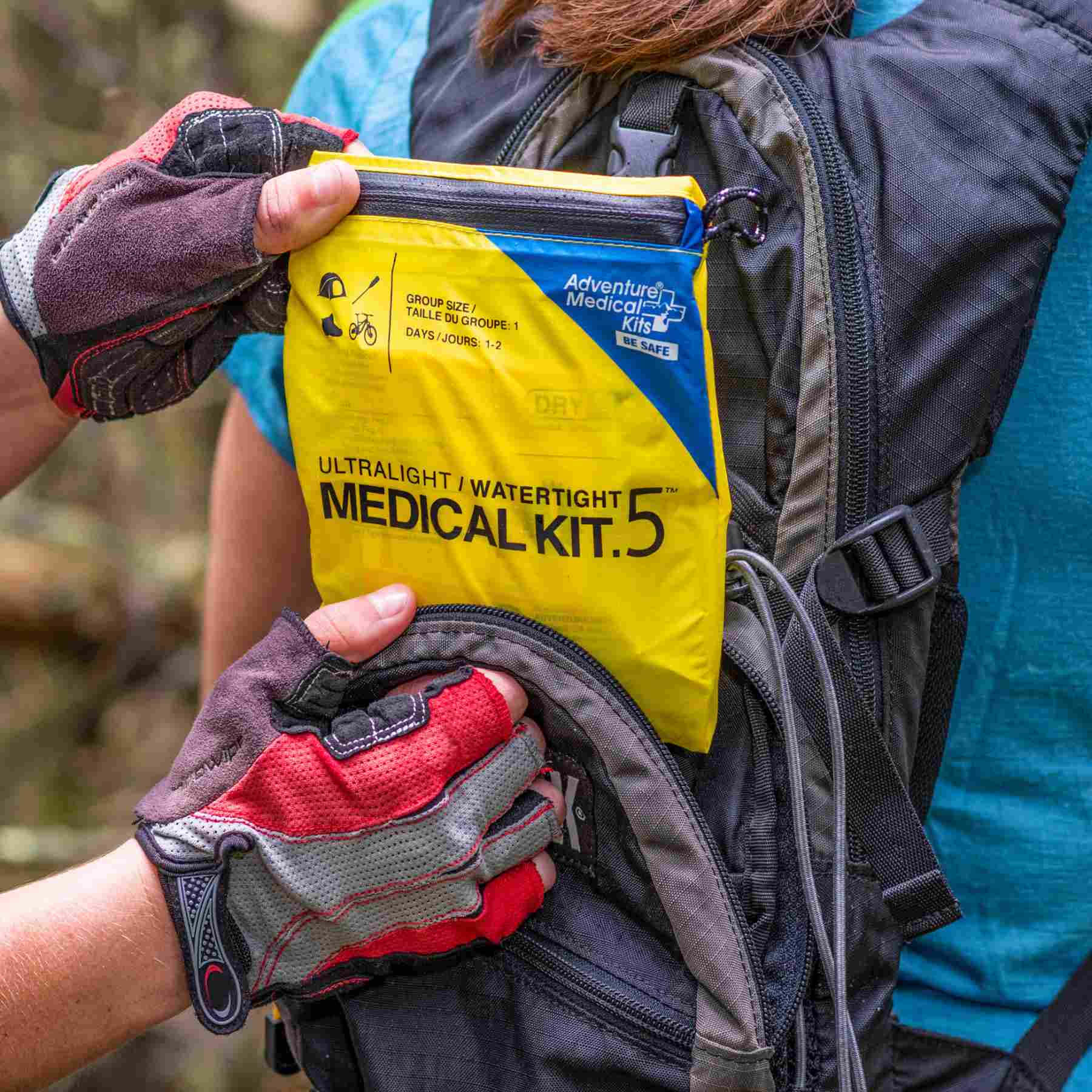 Ultralight/Watertight Medical Kit - .5 removing kit from biker's backpack