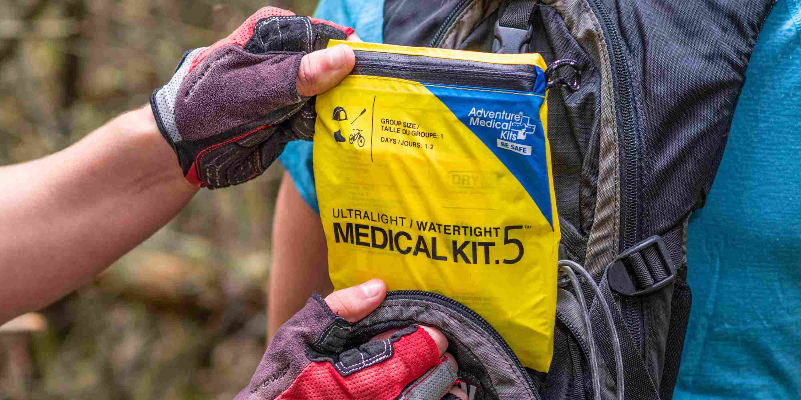 Ultralight/Watertight Medical Kit - .5 removing kit from biker's backpack