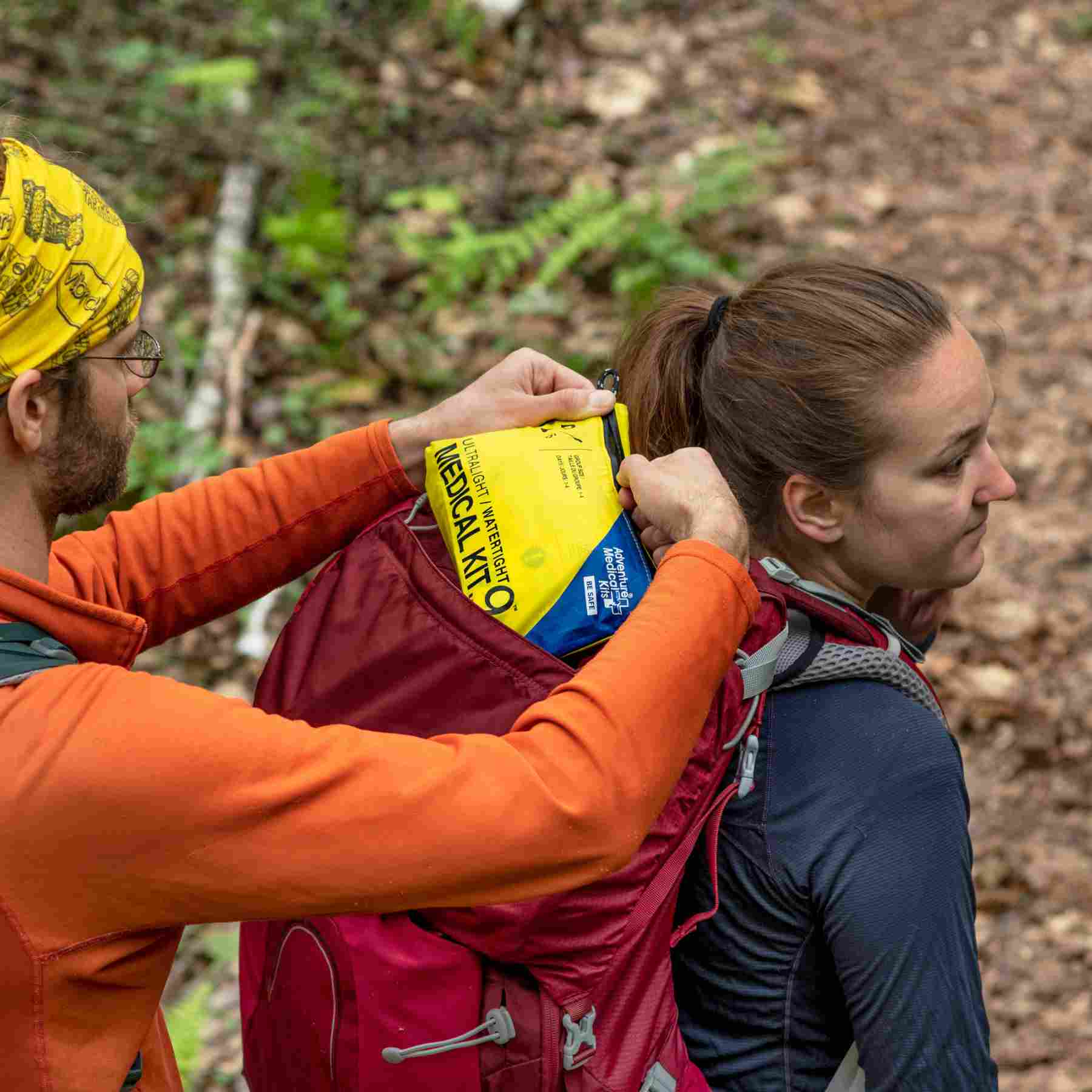 Ultralight/Watertight Medical Kit - .9 friend removing kit from hiker's backpack