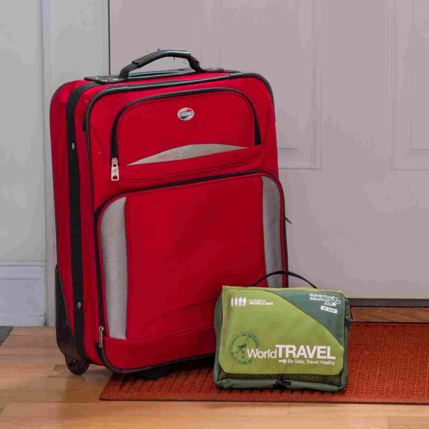 Travel Series Medical Kit - World Travel in front of luggage and door