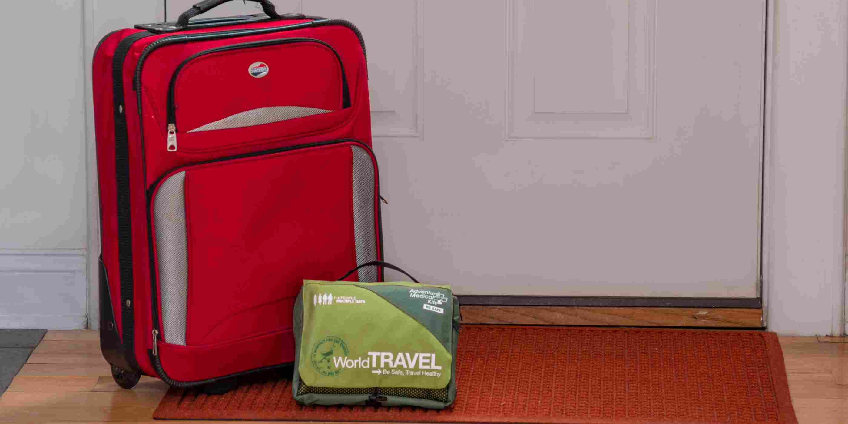 Travel Series Medical Kit - World Travel in front of luggage and door