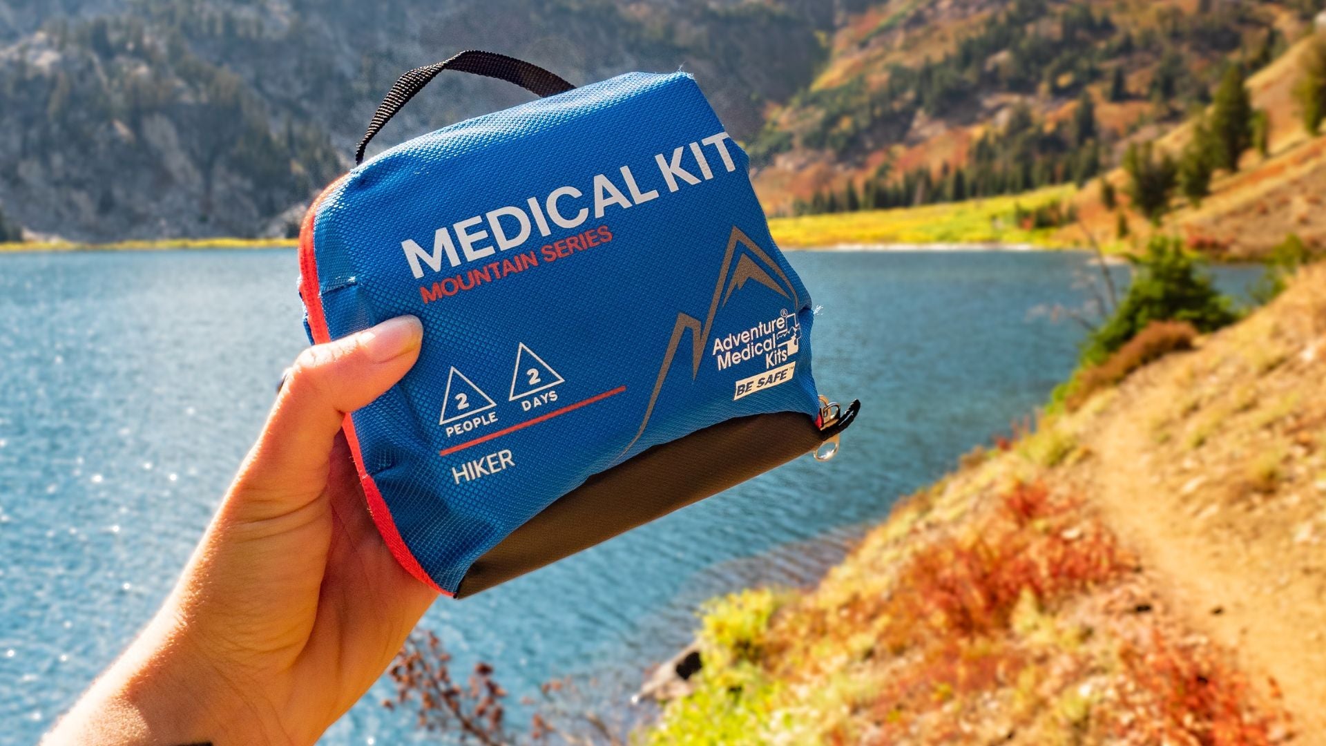 Person holding Hiker Kit in front of water