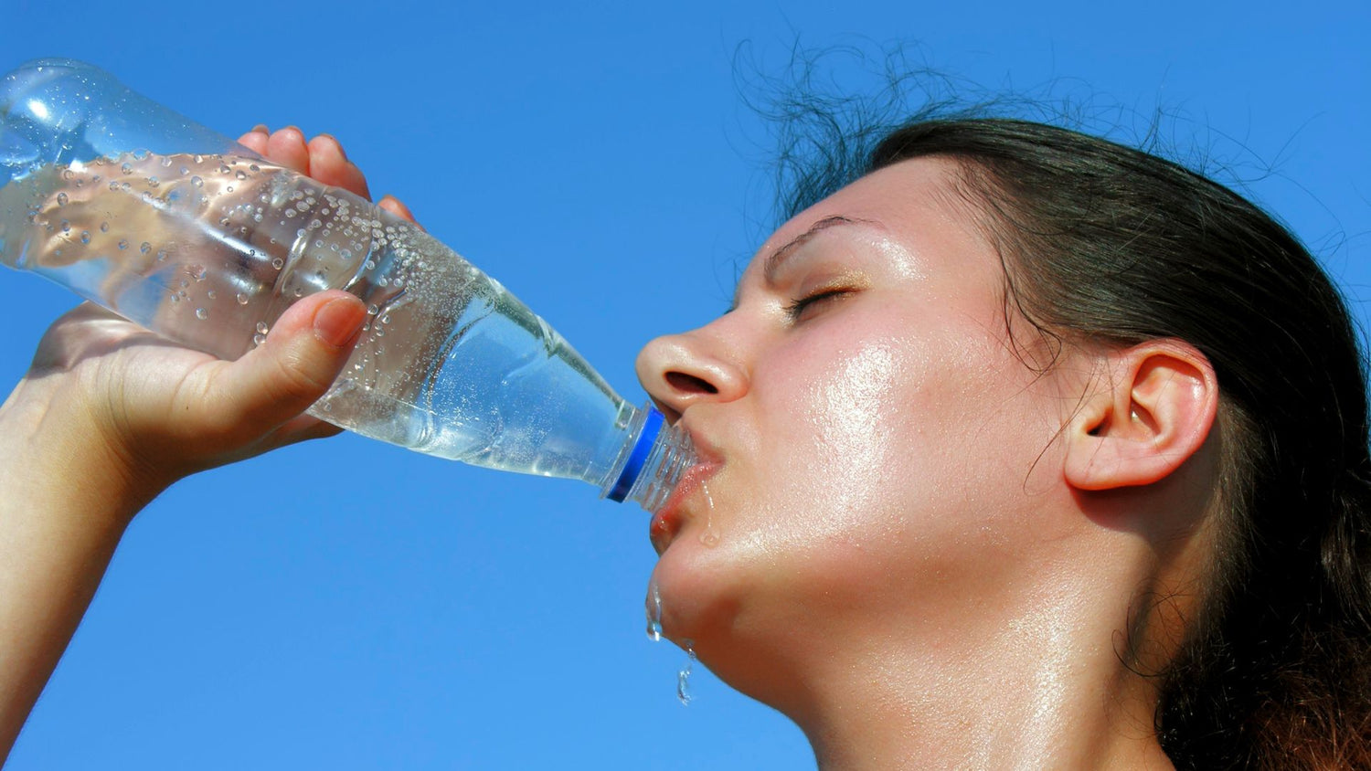 Woman drinking from bottle of water