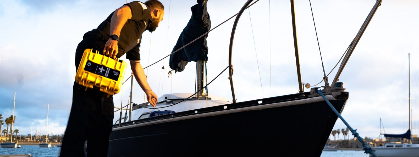 Man holding Marine Kit reaching onto boat