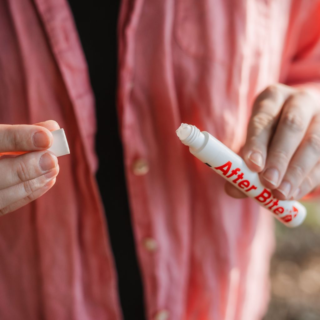 Woman removing cap from After Bite X-Tech