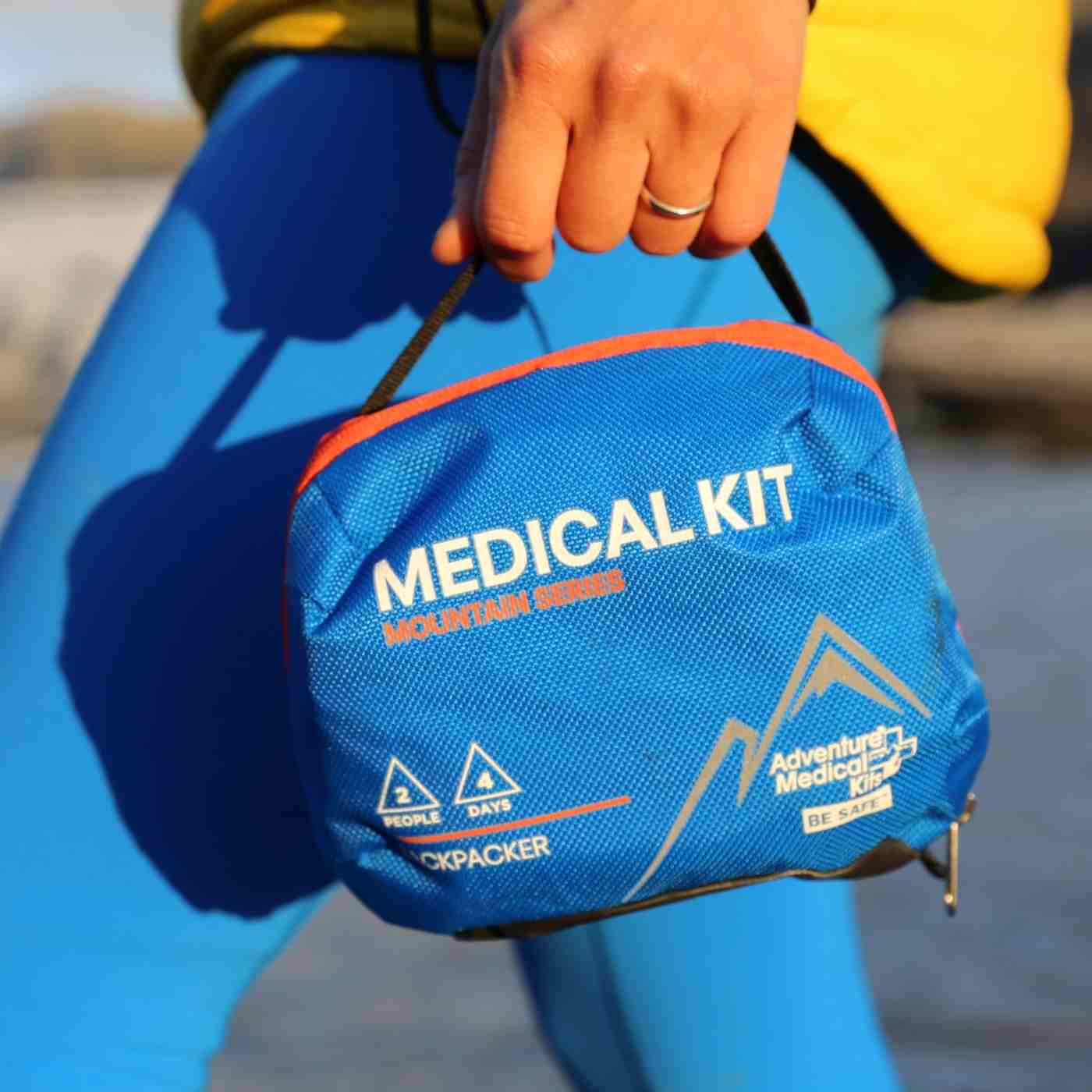 Mountain Series Medical Kit - Backpacker woman in blue leggings carrying kit