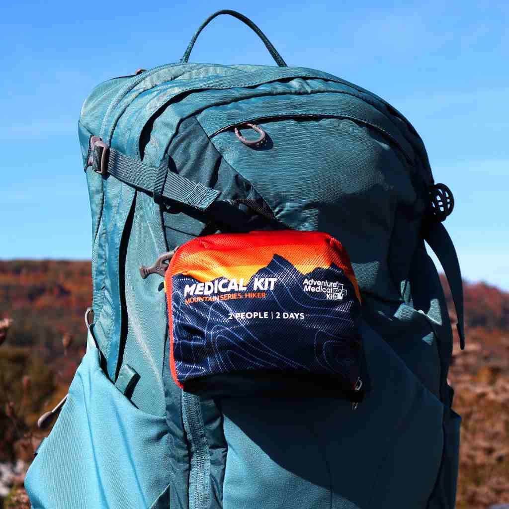 Mountain Series Hiker Sunset Kit on blue backpack in front of mountains in the fall