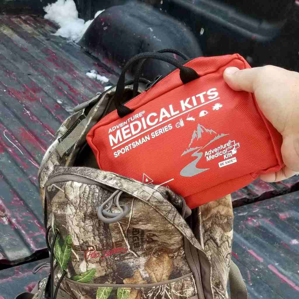 Sportsman Series Medical Kit - 200 removing kit from camo bag on truck bed