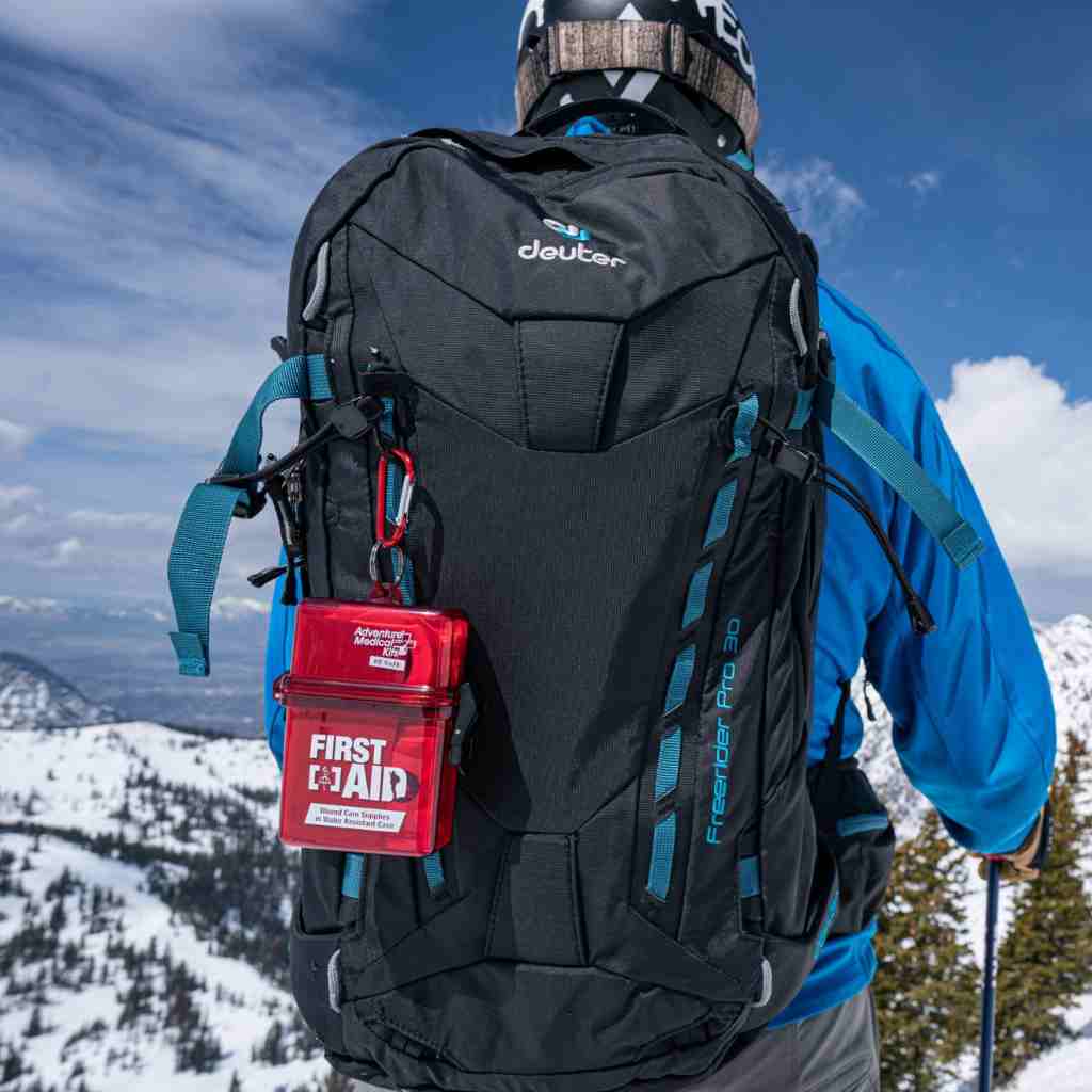 Adventure First Aid, Water-Resistant Kit kit on backpack of person skiing