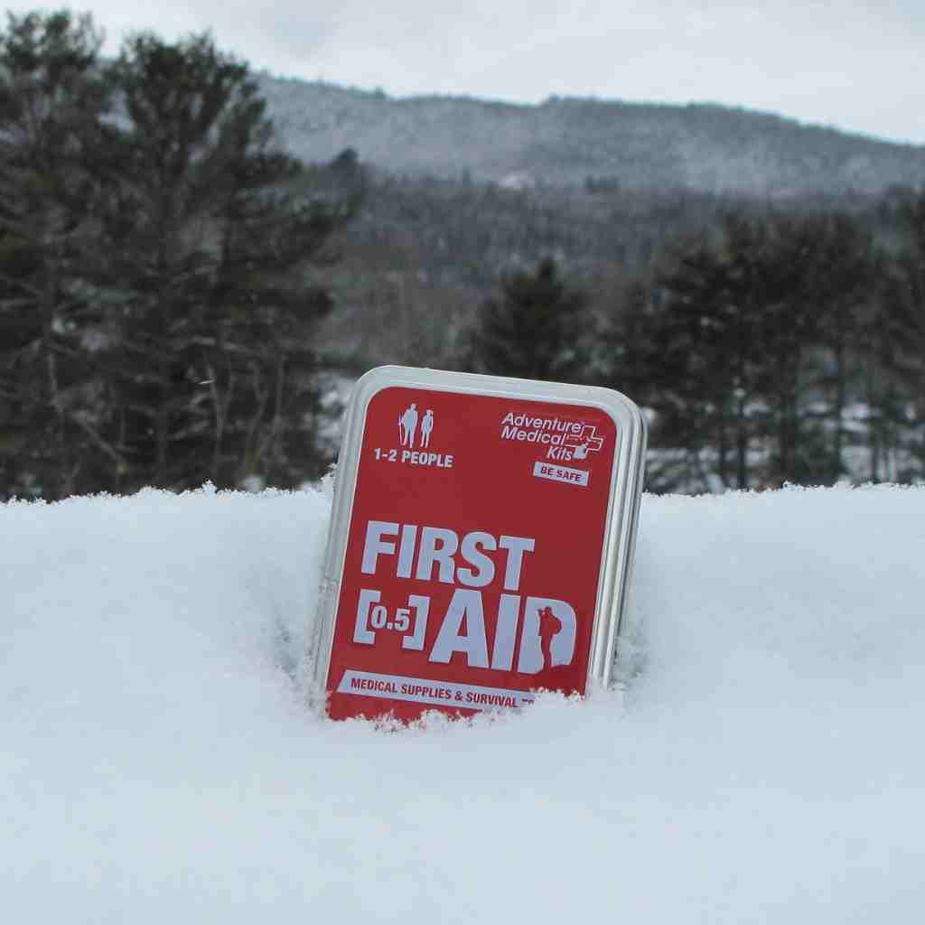Adventure First Aid, 0.5 Tin kit in snow with trees in background