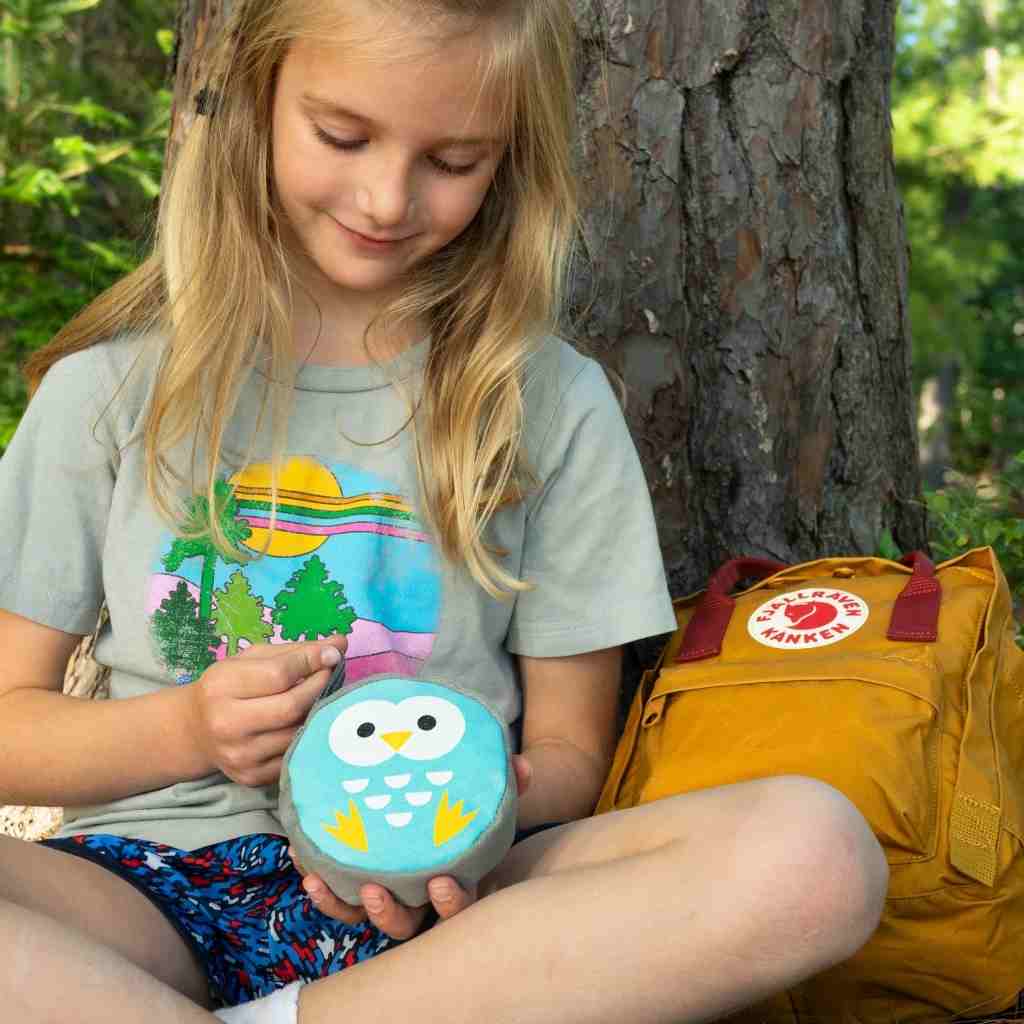 Backyard Adventure Owl First Aid Kit child opening kit seated next to backpack