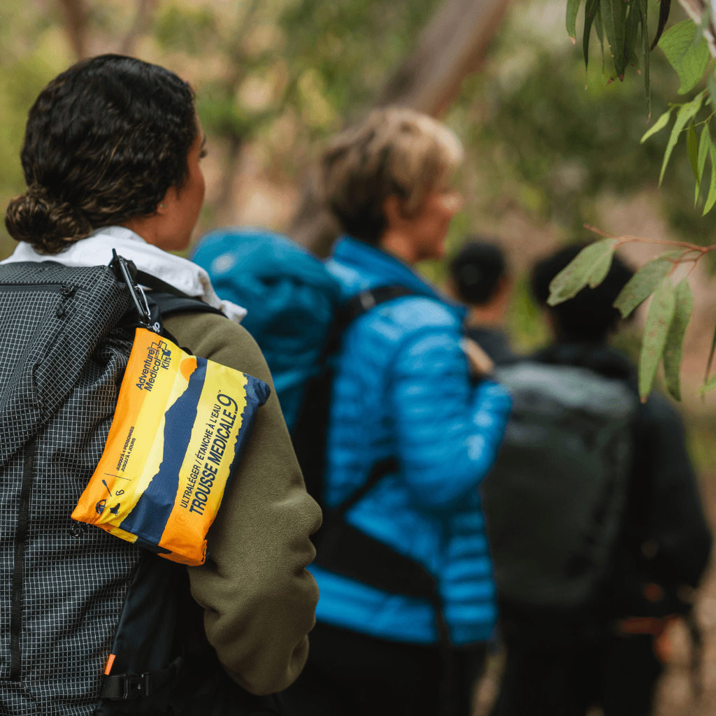 Group of hikers, with the Ultralight / Watertight Medical Kit .9 strapped to a backpack