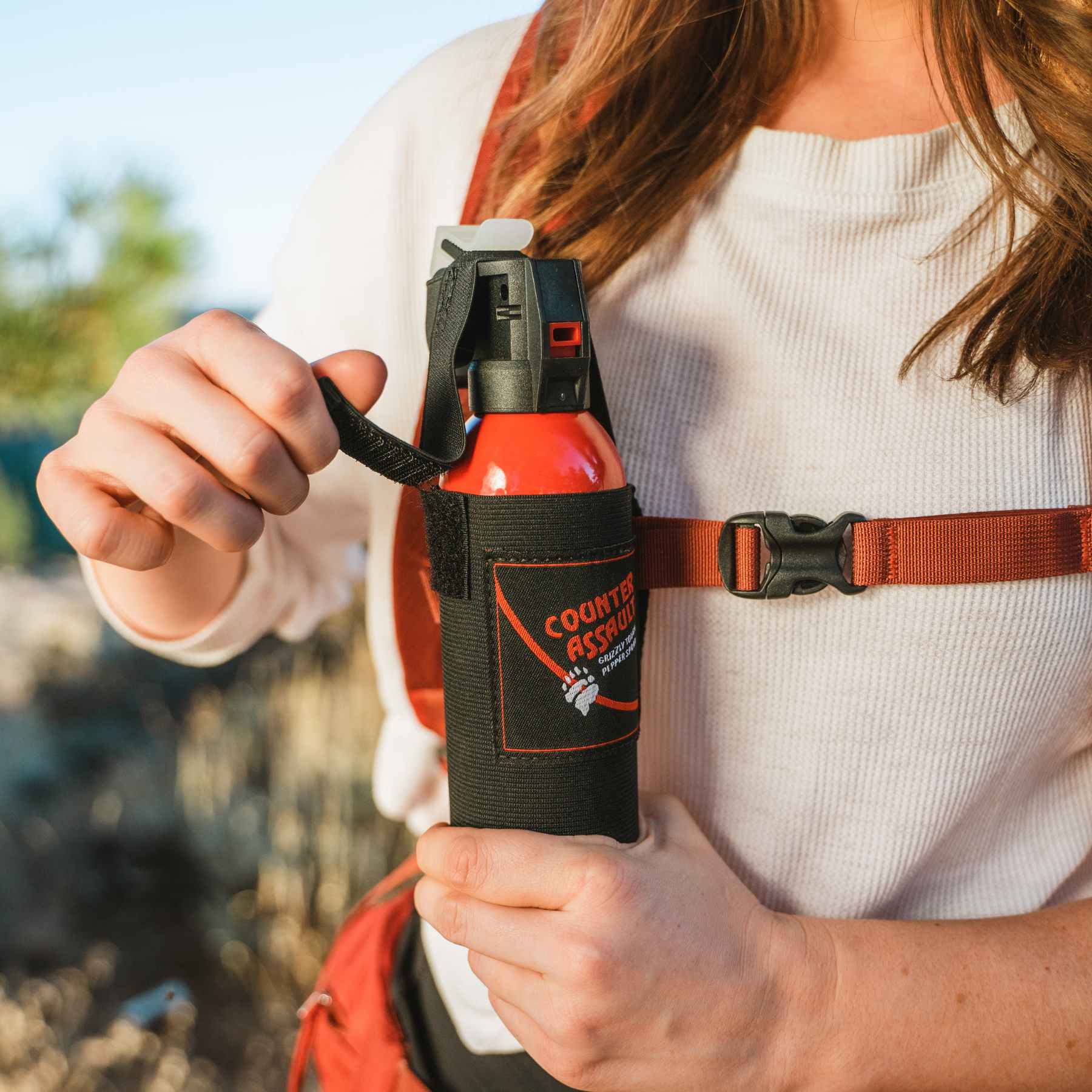 Woman holding a Counter Assault bear deterrent spray