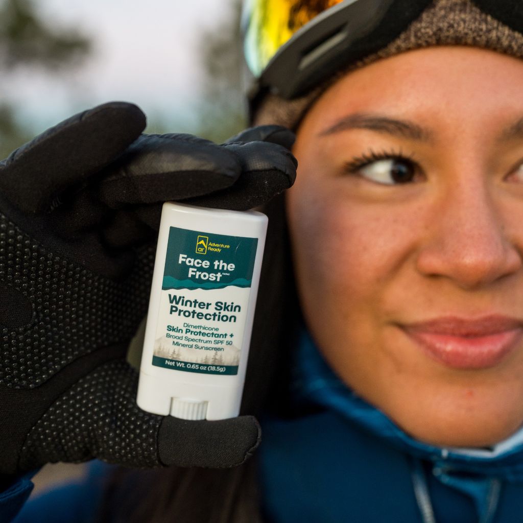 Woman holding Face the Frost next to her face