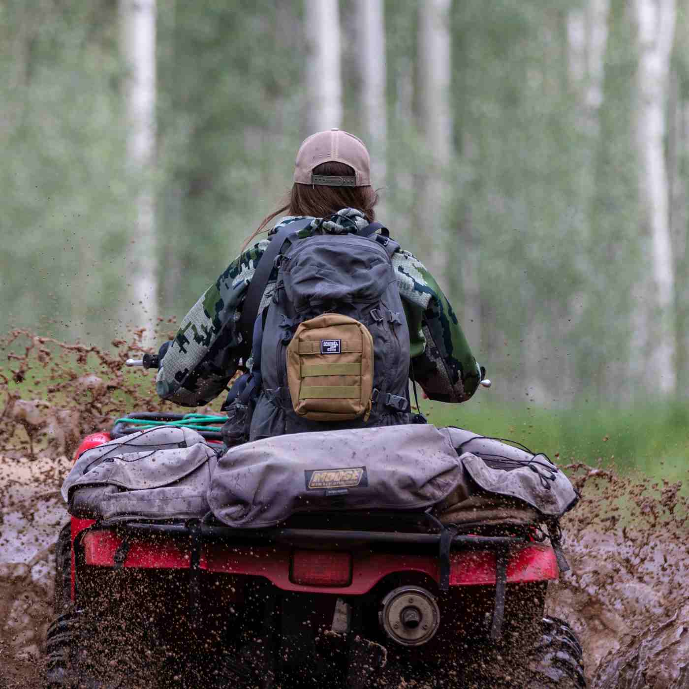 MOLLE Bag Trauma Kit 2.0 - Khaki kit attached to woman's backpack while riding ATV through mud